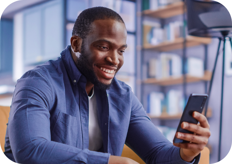 homem negro olhando para tela do celular representando que está olhando seus fundos de investimentos